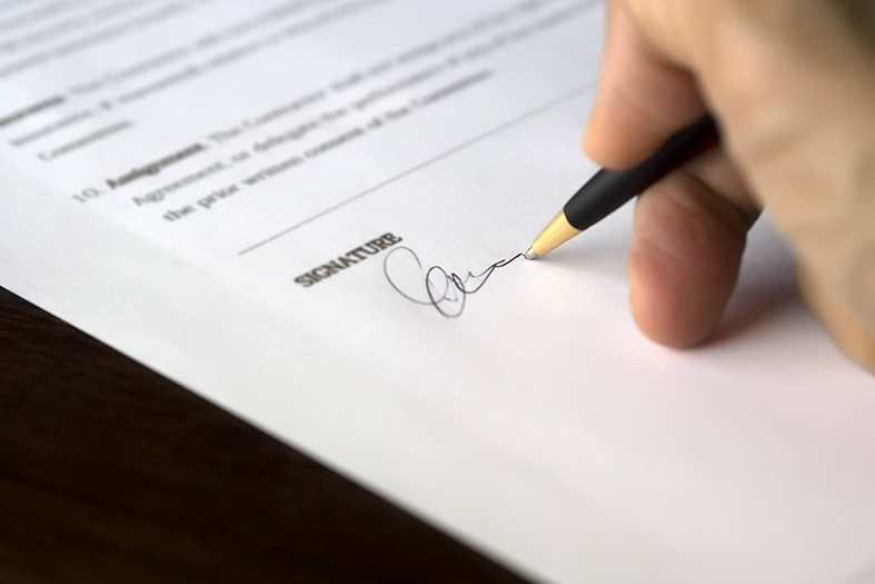 Homem assinando um documento.