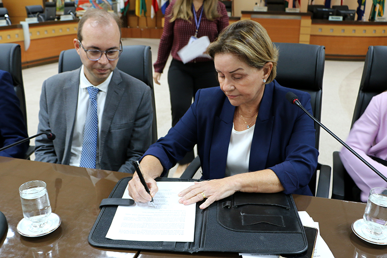 A desembargadora Janete Simões assinando um documento no salão do Tribunal Pleno do TJES.