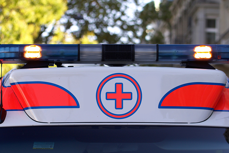 Detalhes como luzes, sirene e símbolos da medicina no teto de um veículo do tipo "ambulância".