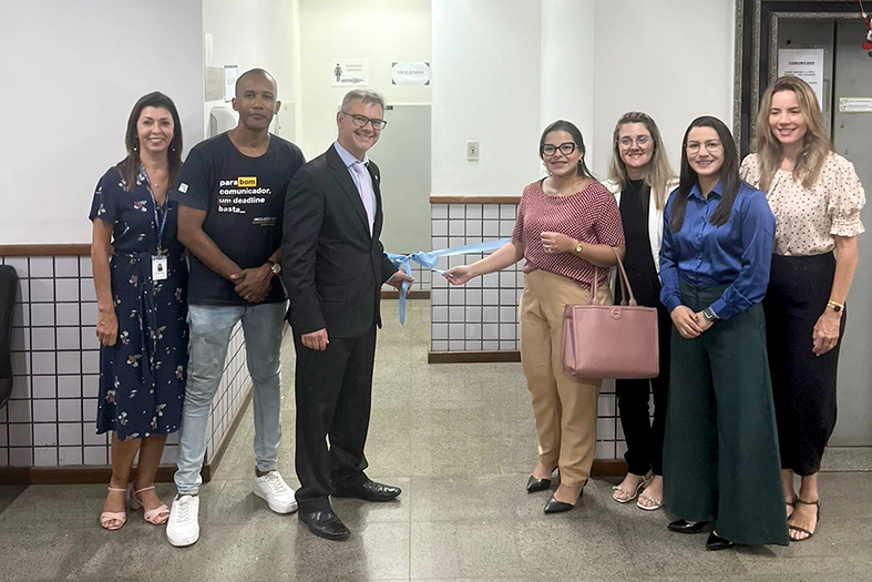 Servidores e Magistrado do fórum de Cachoeiro de Itapemirim/ES posam para foto durante o descerramento de faixa de inauguração do fraldário no prédio do foro.