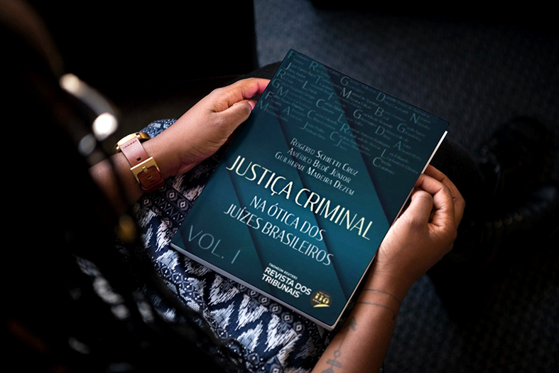 Detalhes de braços de uma mulher segurando um livro em suas mãos.