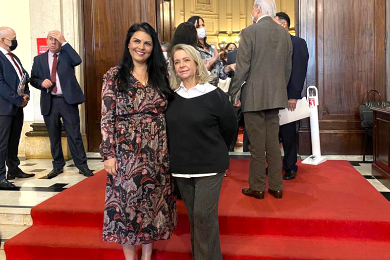 Duas mulheres posam para foto.