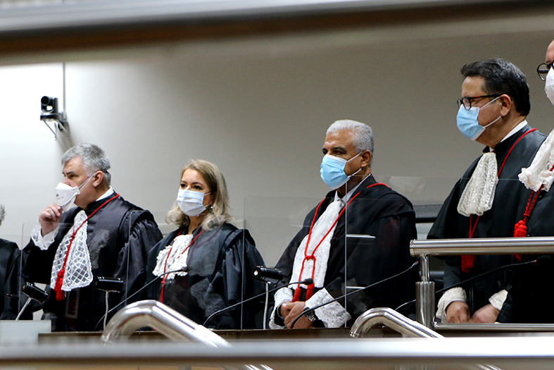 Quatro desembargadores vestindo toga se pé no tribunal pleno.