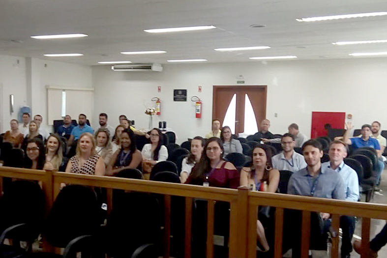 Pessoas assistindo a um treinamento dentro do salão do juri de Colatina, ES.