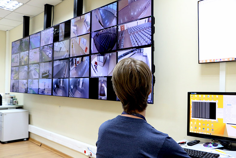 Servidor da assessoria de segurança institucional monitora a segurança da sede do tribunal de justiça através de uma parede com televisores.