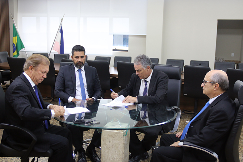 O presidente do TJES, desembargador Fabio Clem, assina documento em seu gabinete.