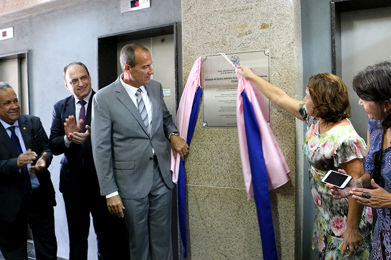 No Fórum Moniz Freire, a placa que marca a instalação do 12º CEJUSC é descerrada pela Desembargadora Janete Simões e pelo Dr. Marcelo Loureiro. Observam a cena, os Juiz de Direito, Dr. Jaime Abreu, o diretor da OAB-ES, Dr. giulio Imbrosi e a procuradora de Justiça, Maria Cabral de Sá.