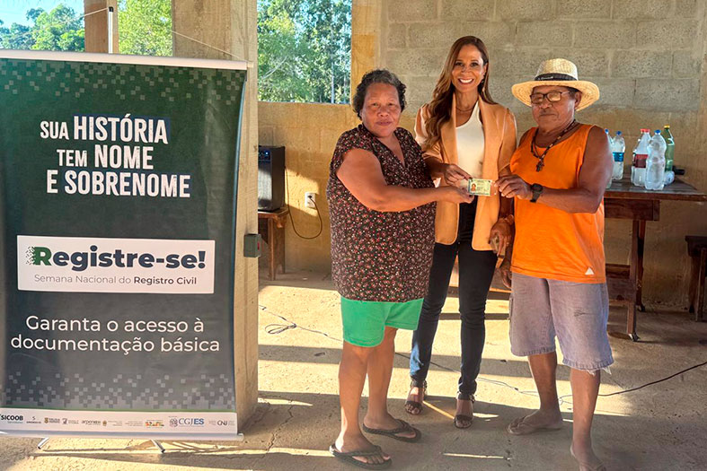 A Juíza Auxiliar da Corregedoria Geral da Justiça, Dra. Gisele Souza de Oliveira posa para foto ao lado de um casal de indígenas da etnia Tupiniquim.