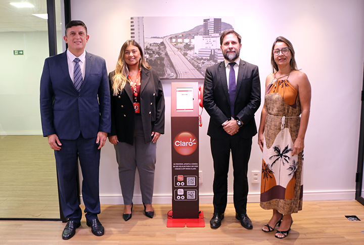 Membros do judiciário capixaba e representante da empresa Claro posam para foto.