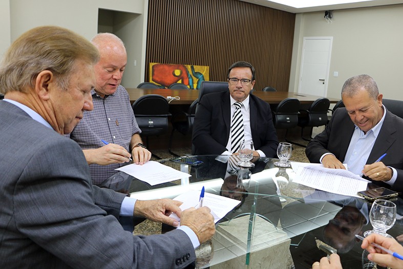 O presidente do TJES, desembargador Fabio Clem, assina documento em seu gabinete.