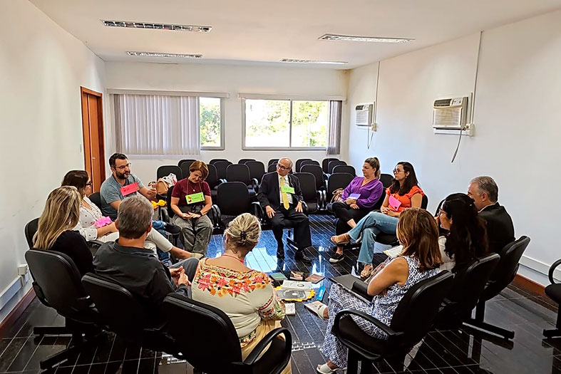 Magistrados e servidores conversam em círculo de cadeiras.