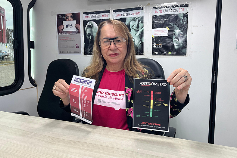 Juíza Hermínia Azoury segura o cartaz do violentômetro de do assediômetro.