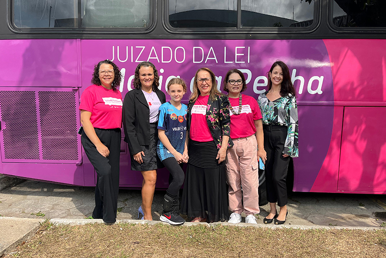 Pessoas em frente ao ônibus rosa