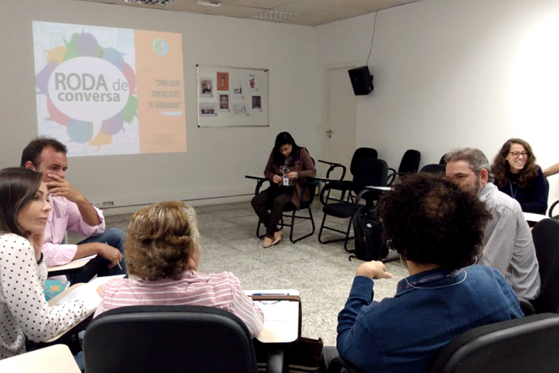 Pessoas sentadas em círculo debatendo entre si.