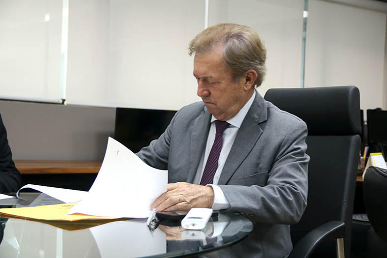 O presidente do TJES, desembargador Fabio Clem, assina documento em seu gabinete.