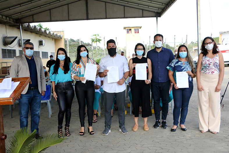 Grupo de pessoas posam para foto.