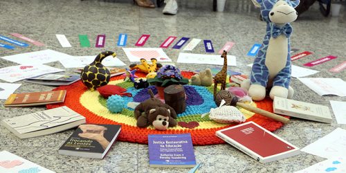 Vários brinquedos dispostos em círculo no cão do auditório da Corregedoria durante a promoção do Ciclo de Paz.