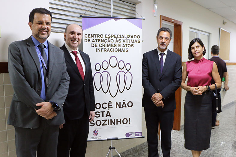 Autoridades do judiciário capixaba posam ao lado de banner com os dizeres "centro especializado de atenção às vítimas de crimes e atos infracionais".