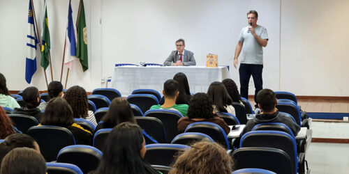 Auditório cheio de crianças e adolescentes que assistem a uma palestra.