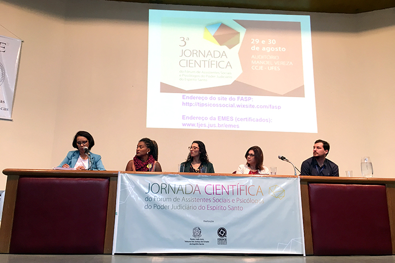 4 mulheres e 1 homem apresentam a 3ª Jprnada Científica da FASP-PJES em um auditório.