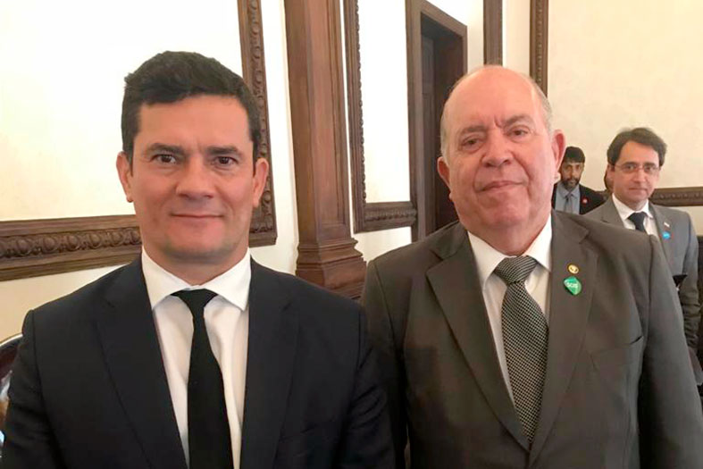 Dois homens de terno posam para foto.