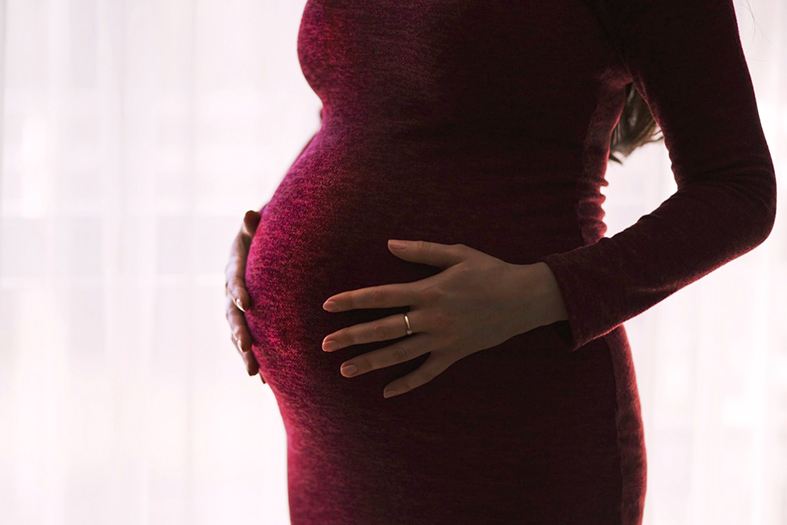 mulher grávida com as mãos repousadas sobre a barriga