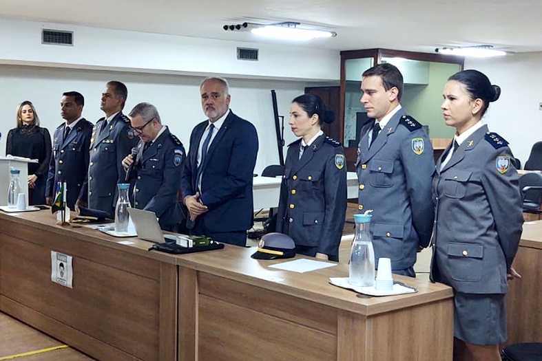 Autoridades se posicionam de pé atrás da mesa de honra do seminário.