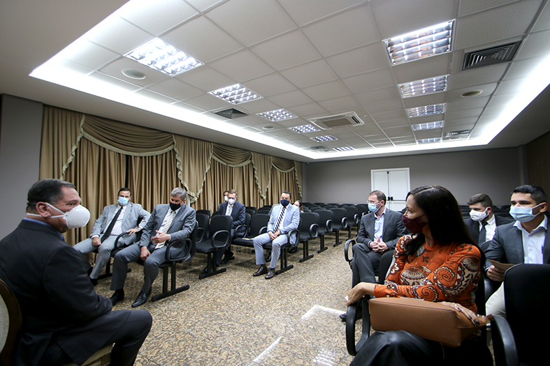 grupo de pessoas conversa sentada em um pequeno auditório