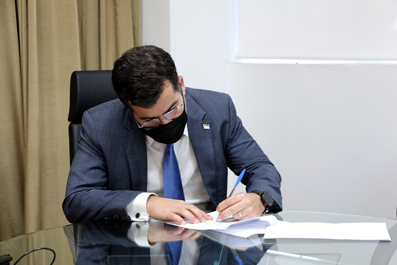 O Procurador-Geral do Estado, Jasson Amaral Hibner, assinando um documento.