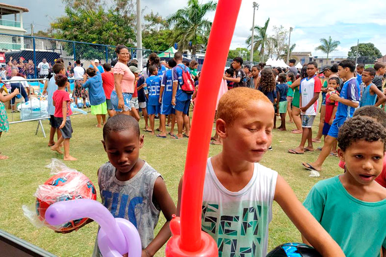 Crianças brincam com balões infláveis.