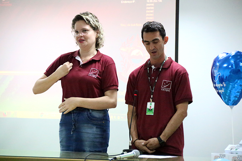 Dois supervisores do projeto de digitalização de processos fazem o cerimonial em português e libras durante evento na CGJ.