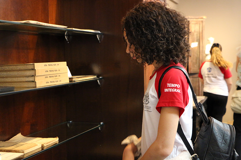 Meina observa documentos históricos no centro de memória do tjes.