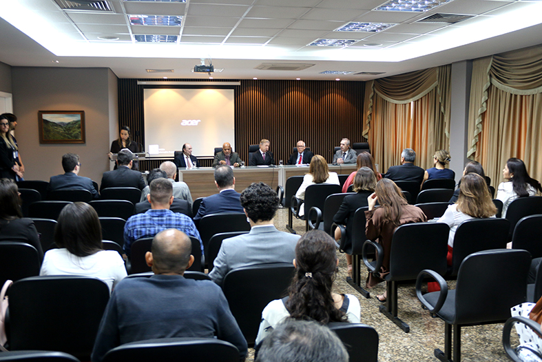 Autoridades do judiciário em mesa de honra durante palestra do ministro Kukina do STJ.