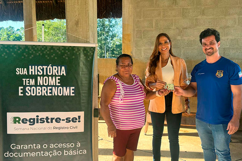 A Juíza Auxiliar da Corregedoria Geral da Justiça, Dra. Gisele Souza de Oliveira posa para foto ao lado de um casal de indígenas da etnia Tupiniquim.