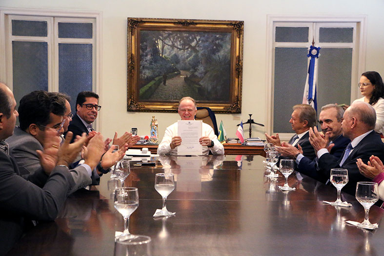 O governador do Espirito Santo, Renato Casagrande mostra documento assinado para a câmera.