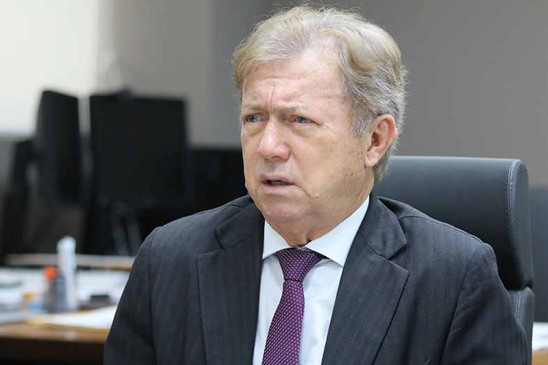 O presidente do TJES, desembargador Fabio Clem, homem de pele branca, com cabelos brancos, fala em seus gabinete. 