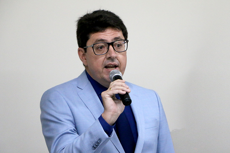 O juiz Akel de Andrade Lima, homem de pele branca e com cabelos na cor preta, fala ao microfone.