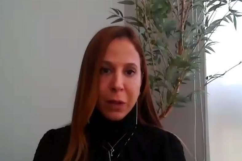 juíza gisele oliveira, mulher morena de estatura mediana, de cabelos longos e castanhos, vestindo uma camisa de de gola alta na cor preta