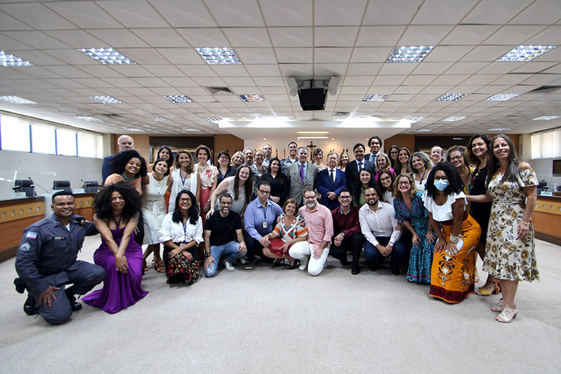Grupo de pessoas posam para foto.