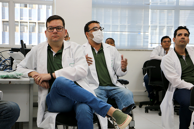 Homem, portador de deficiência física, fala para os colegas colaboradores.