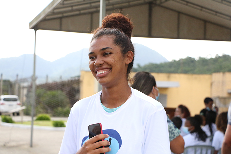 Mulher de negra parda sorrindo.