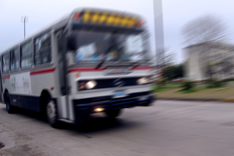 Ônibus se deslocando por uma avenida.