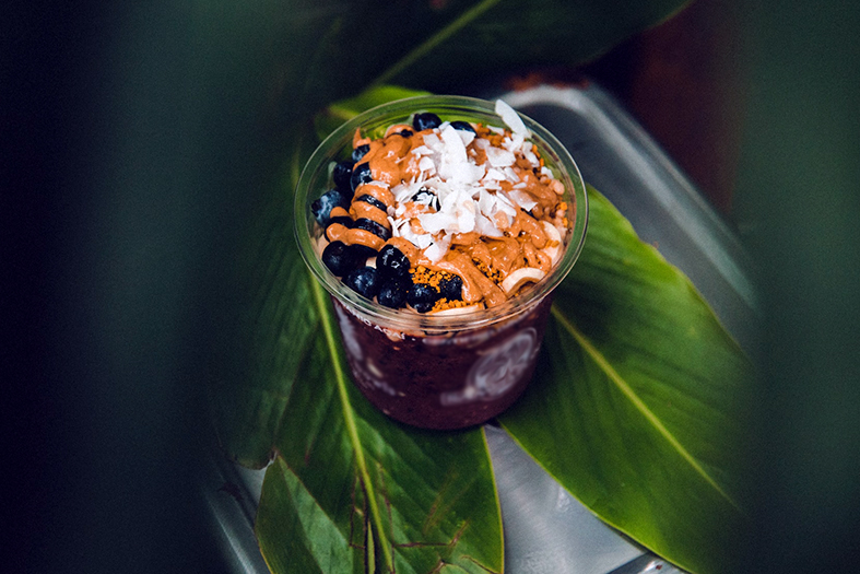 pote pequeno de açaí com cobertura de produtos comestíveis variados.