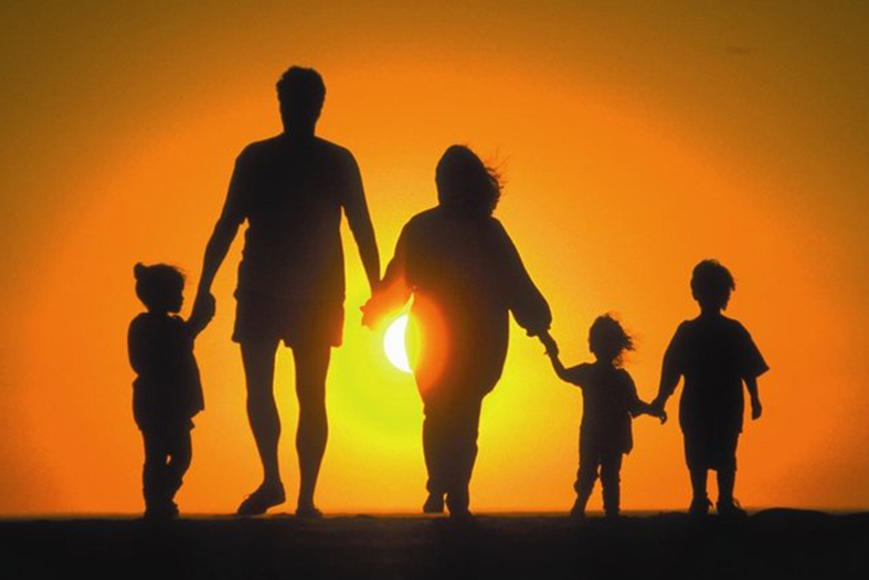 uma família andando em direção ao pôr do sol