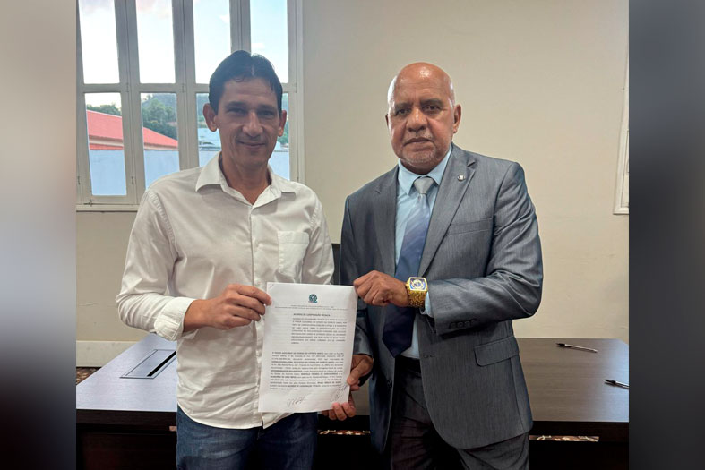 O Corregedor Geral da Justiça, Desembargador Willian Silva e o Prefeito do município de João Neiva (ES), Paulo Sérgio de Nardi posam para foto segurando o acordo de cooperação técnica sobre a regularização fundiária.