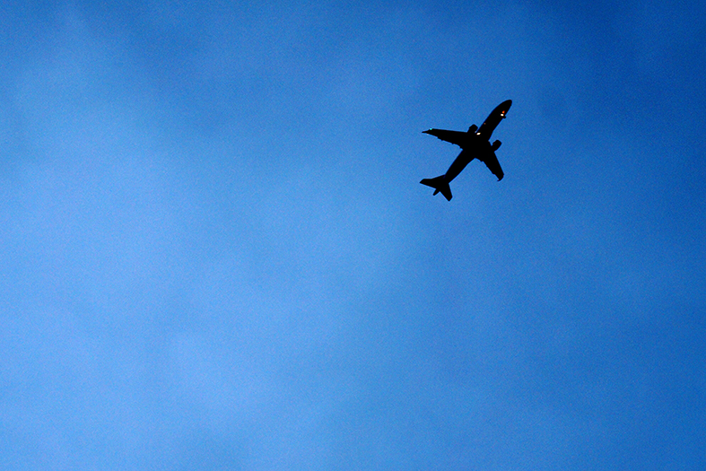 Silhueta de avião sobre céu azul.