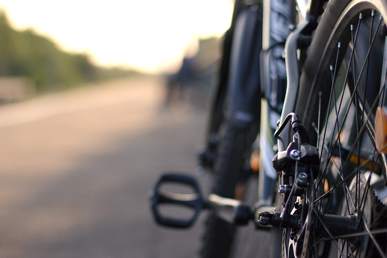 Detalhe de um quadro de bicicleta onde se vê o pedal esquerdo em evidência.