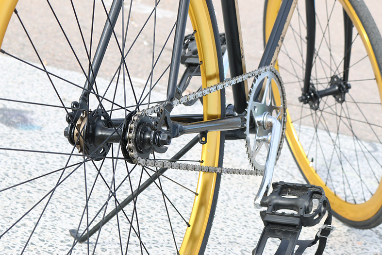 Bicicleta na cor preta com detalhes na roda na cor amarela.
