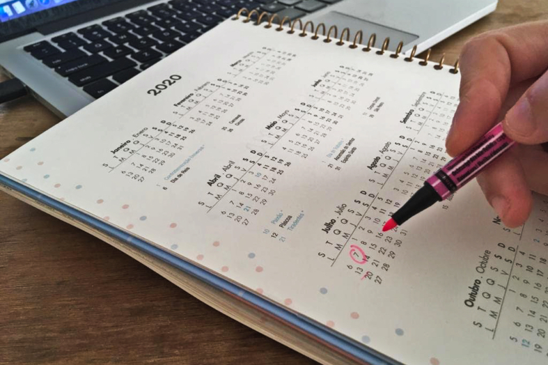 Pessoa marcando uma data em um calendário.