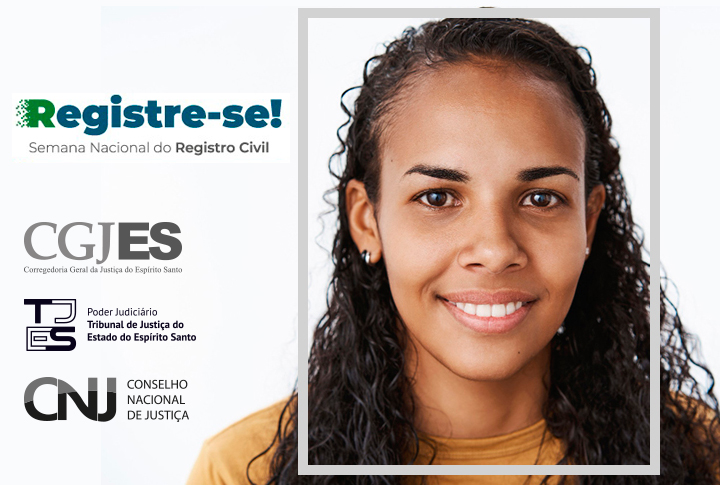 Mulher negra e com cabelos anelados sorri para a câmera.